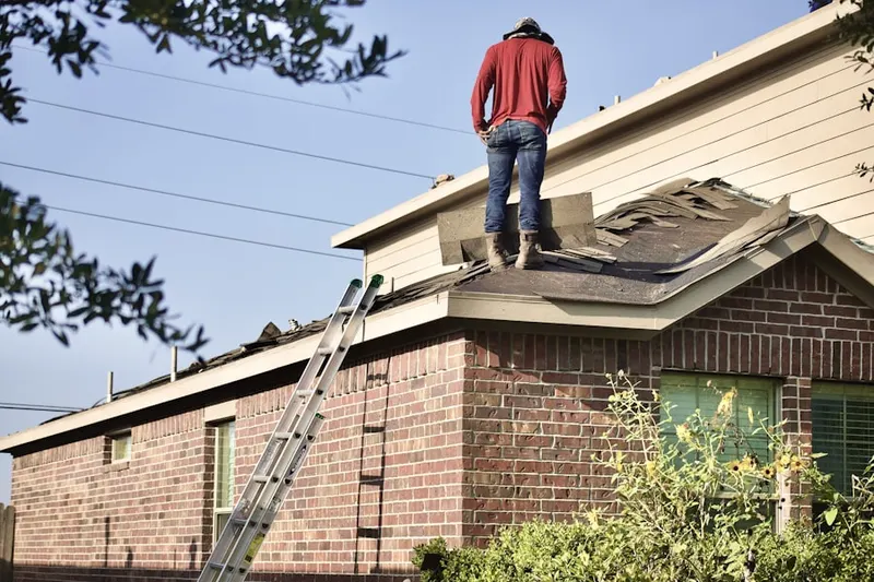 Professional roofer working on a residential roof in Valley Stream